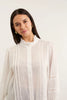 Woman wearing a white blouse with a plain background