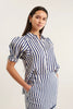 Woman wearing a blue and white striped dress against a plain background