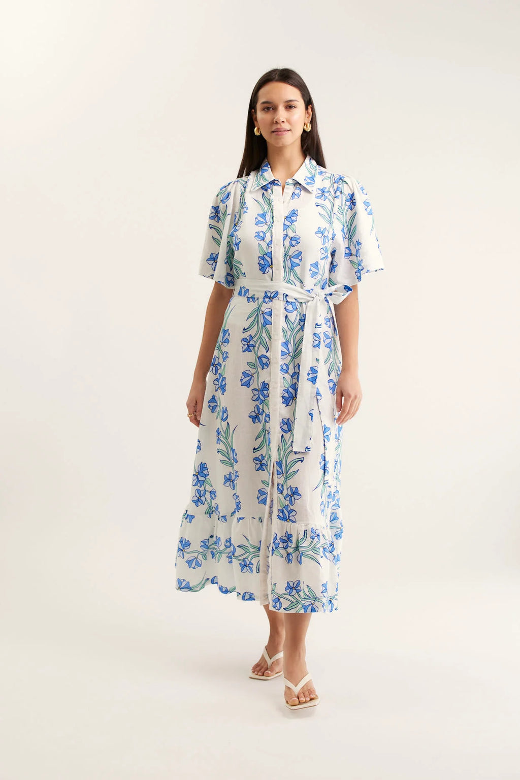 Woman wearing a white dress with blue floral pattern on a white background