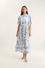 Woman wearing a white dress with blue floral pattern on a white background