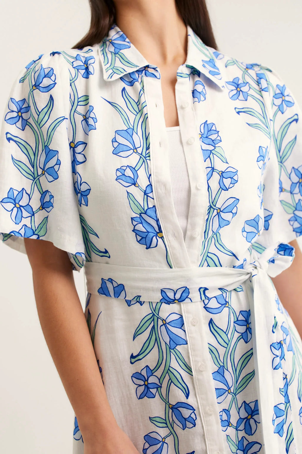 White dress with blue floral pattern worn by a person