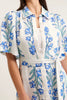 White dress with blue floral pattern worn by a person