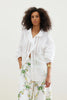 The Zicatela Shirt from Binny is a lightweight white cotton voile shirt with intricate hem embroidery, gently shirred sleeves and sweetly ruffled lapel. 