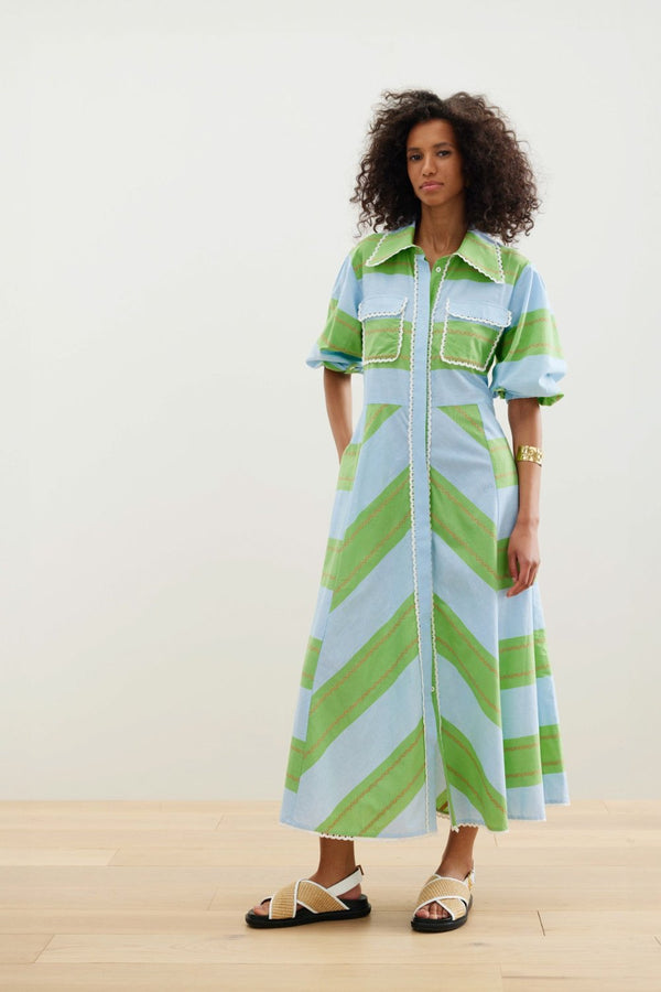 The Legend of San Blas Dress from Binny features yarn dye sky blue and grass green cotton poplin stripes with a tiny wiggle of orange, finished with cotton crochet lace trim.