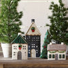 Decorative ceramic houses with Christmas trees on a wooden surface