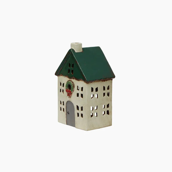 Small decorative house with a green roof on a white background
