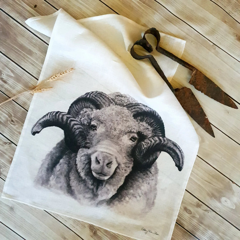 White linen tea towel with hand drawn ram head on bottom half. Image drawn by Cathy hamilton